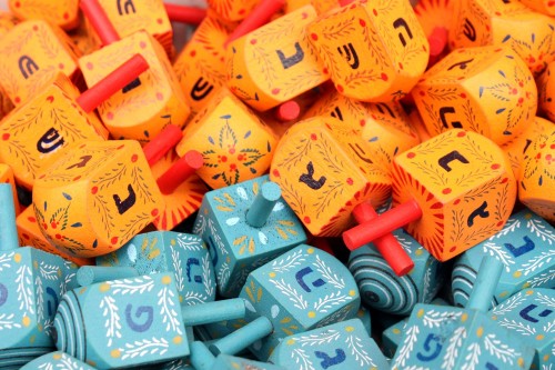 Colorful Hanukkah tops at Machne Yehuda market in Jerusalem [Photo: Adiel Io, Wikimedia Commons]